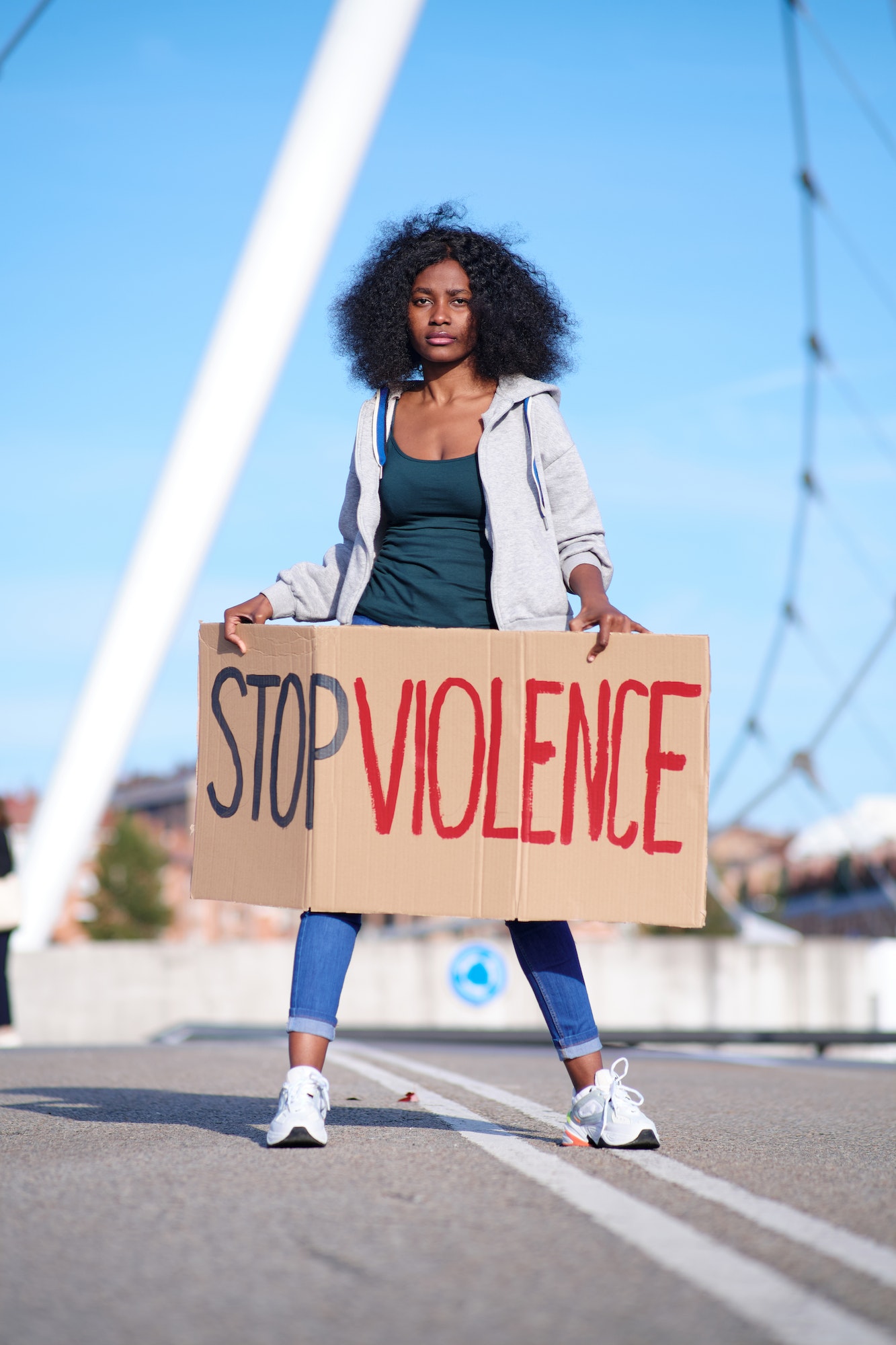 A young African-American protester holding a banner and protesting against violence against women.